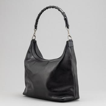 Gucci, a black leather handbag.