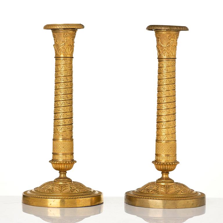 A pair of French Empire ormolu candlesticks, early 19th century.