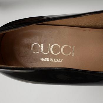 GUCCI, a pair of black patent leather shoes.