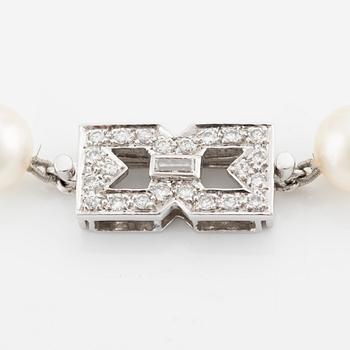Pearl necklace, longer model, cultured pearls, clasp in 14K white gold with baguette and brilliant-cut diamonds.