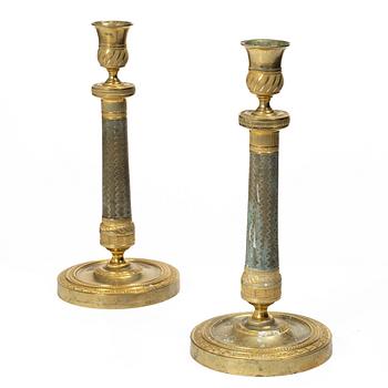 A pair of French Empire ormolu candlesticks, early 19th century.