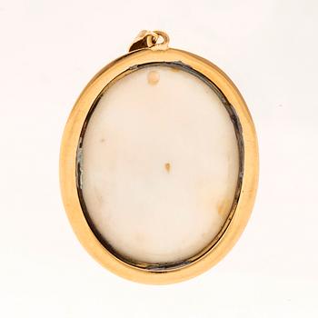 A pendant set with a shell cameo and 18K gold.