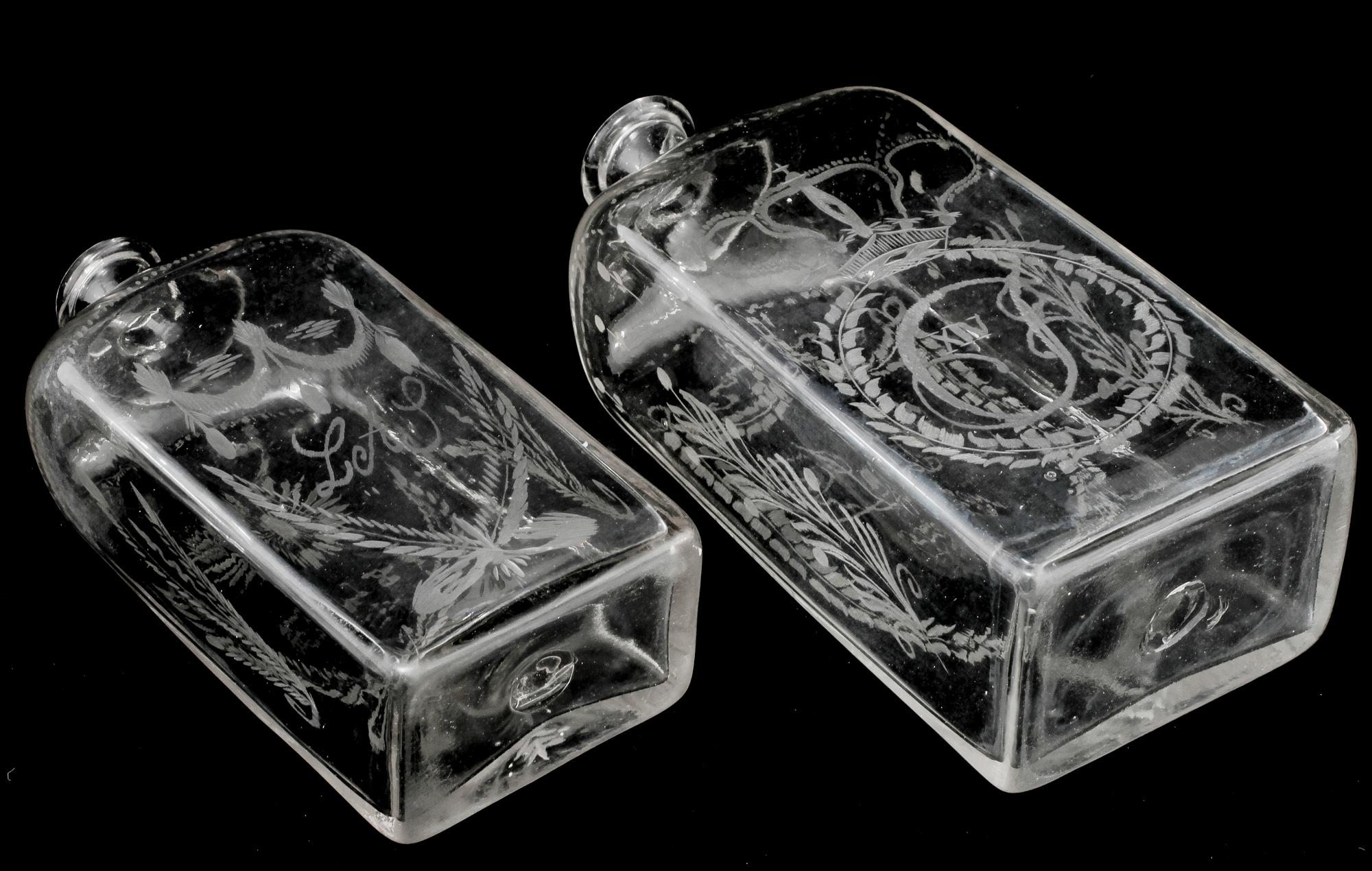 BRÄNNVINSFLASKOR, 2 st, glas, daterade 1833 respektive 1843.