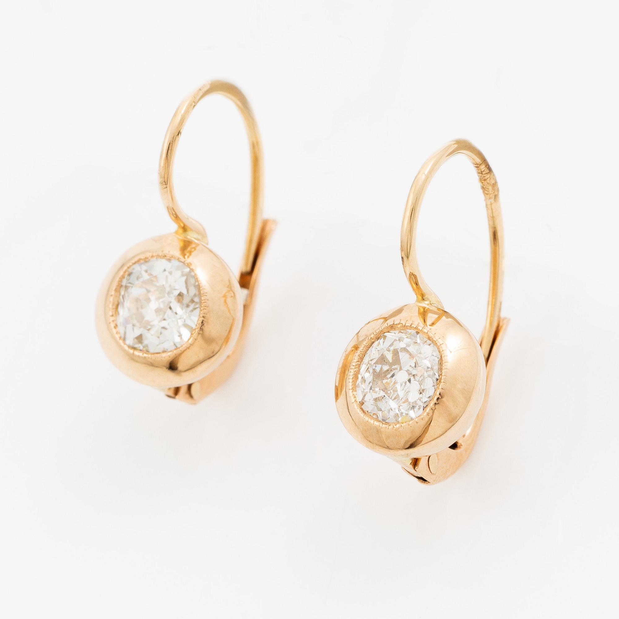 A pair of earrings in 18K gold set with two old-cut diamonds.