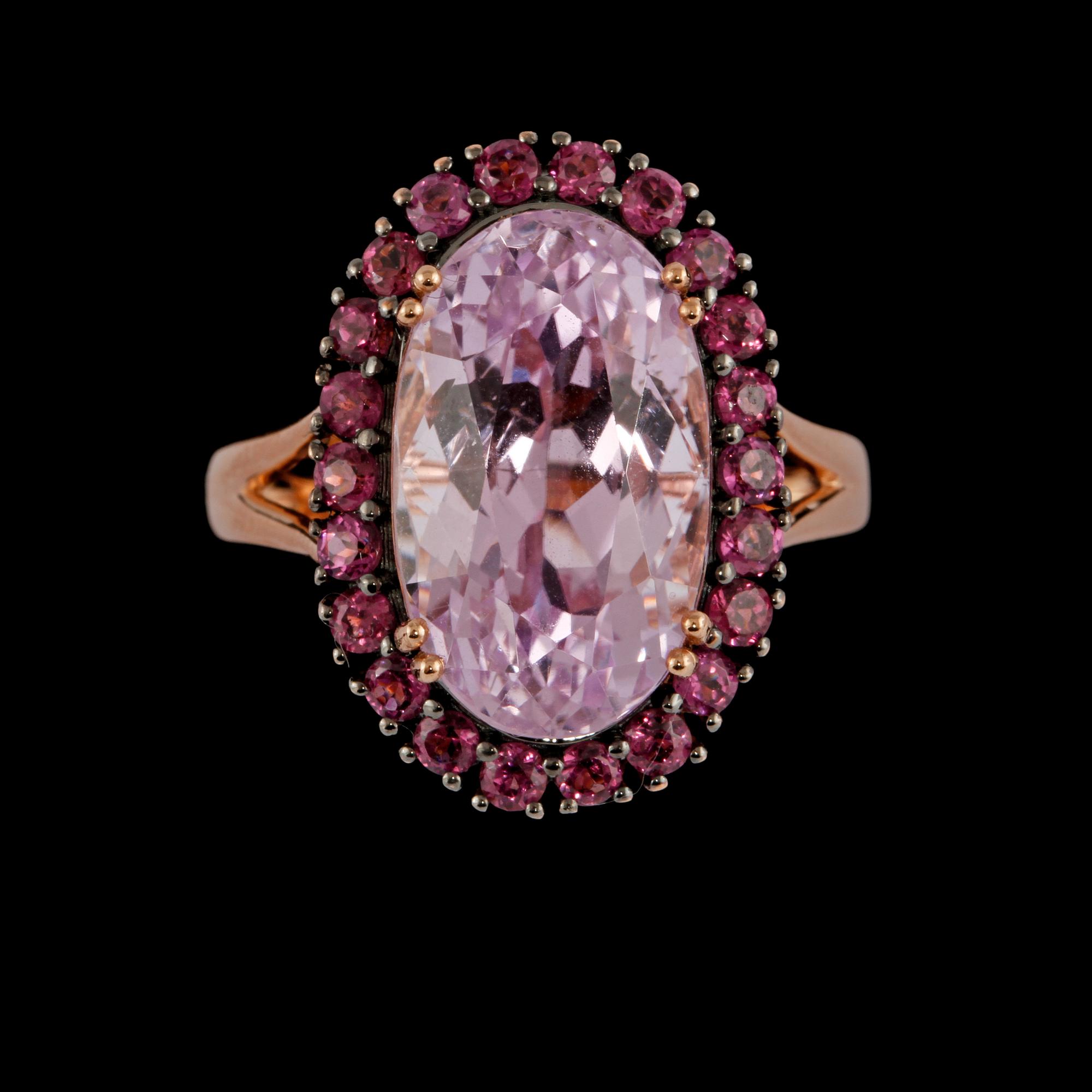 RING, 18K guld med ovalslipad rosa kunzit 9.41 ct samt fasettslipade granater 1.15 ct. Vikt 6,9 gram.