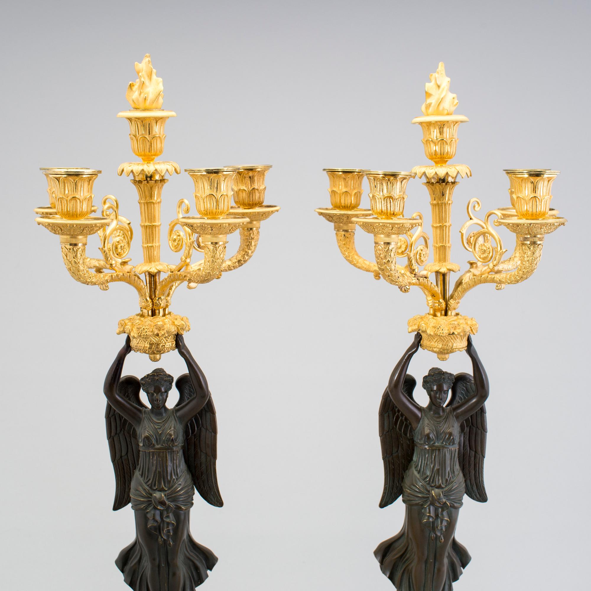 A large pair of first half of the 19th century gilt and patinated bronze five-light candelabra.