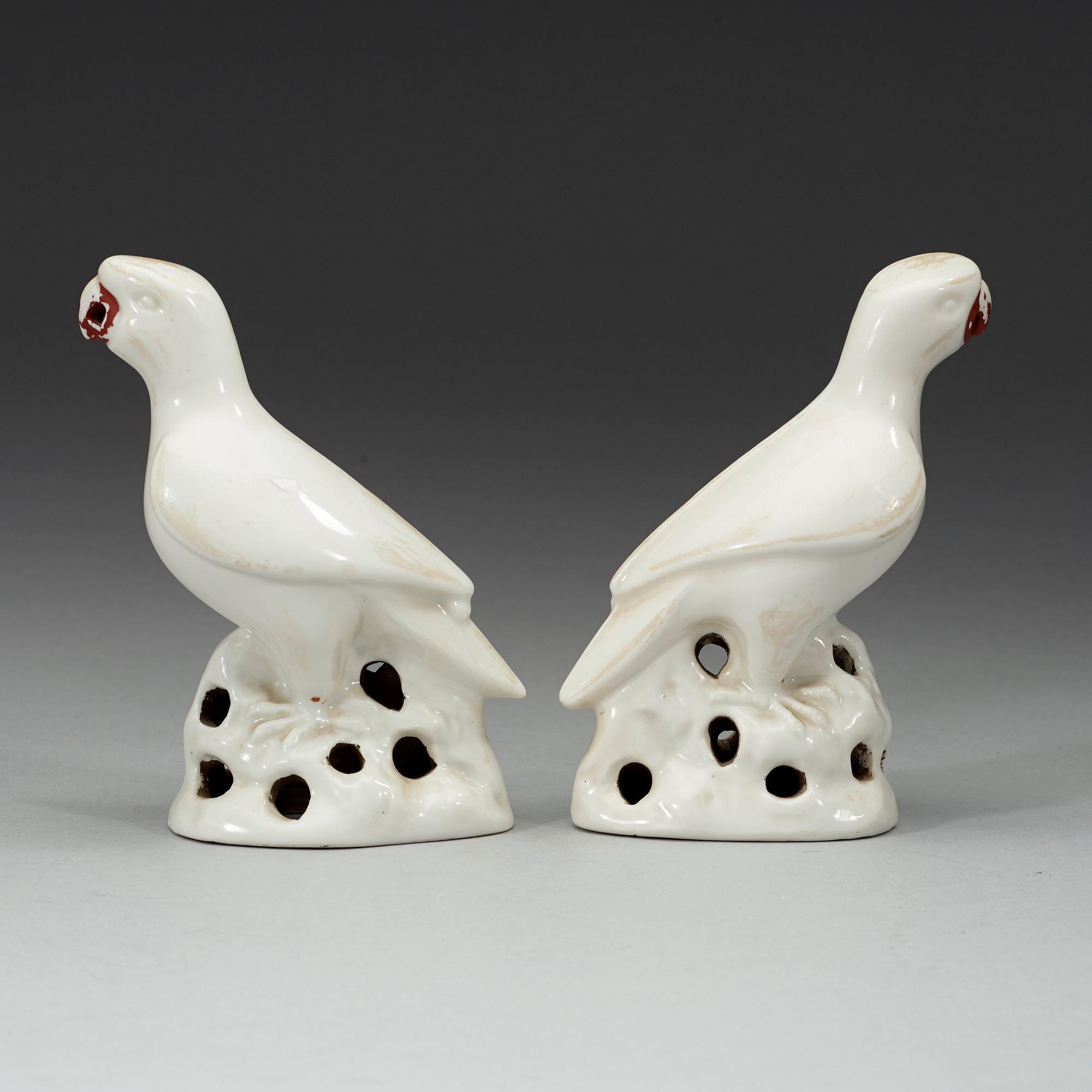 A pair of white and red glazed figures of parrots, late Qing dynasty.