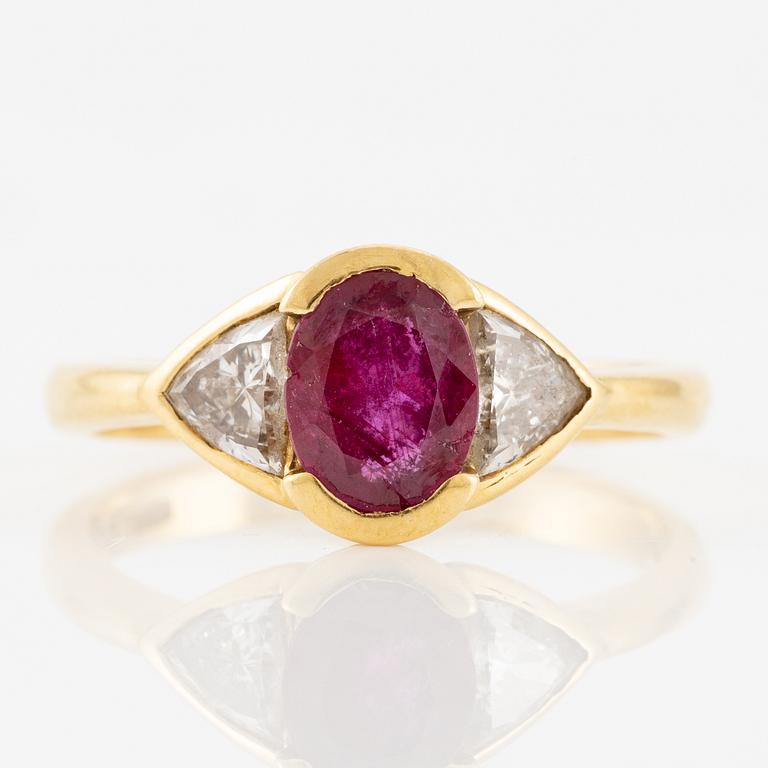 Ring 18K guld med en fasettslipad rubin samt två triangelformade briljantslipade diamanter.