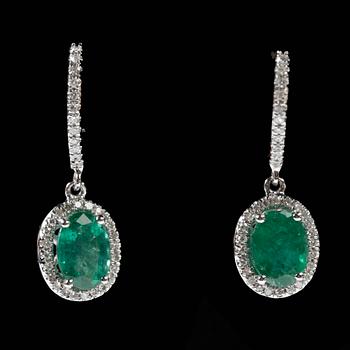ÖRHÄNGEN, ett par, 14k vitguld med ovala smaragder vardera ca6x8x5mm, totalt ca2,54ct o diamanter tot ca0,18ct. Vikt 4g.