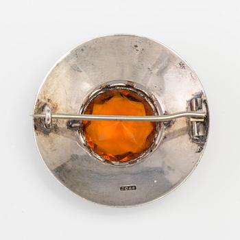A BROOCH set with amber coloured paste.