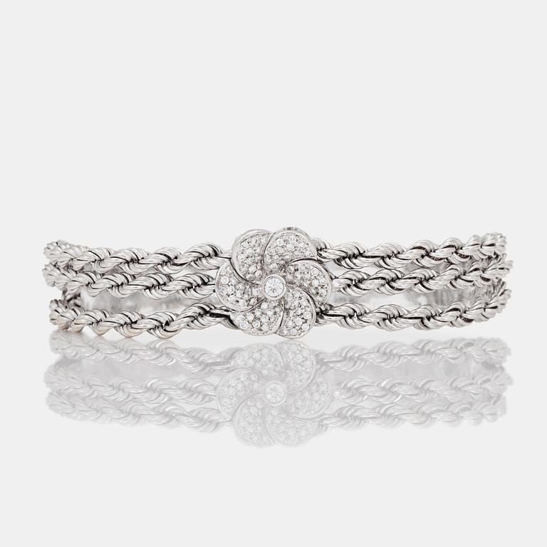 ARMBAND med tre stycken diamantklädda blommor.