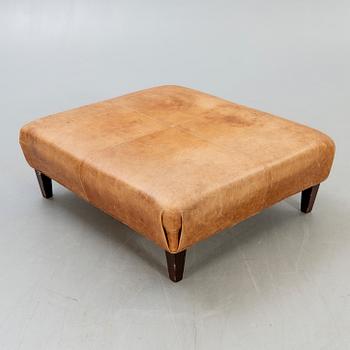 A leather ottoman/coffee table alter part of the 20th century.