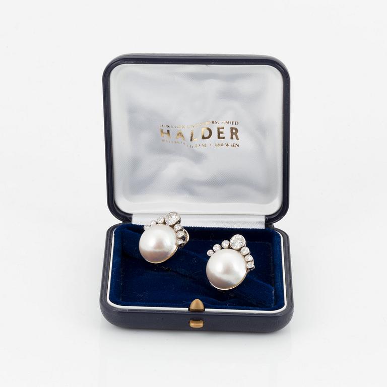 A pair of 18K white gold earrings set with mabe pearls and round brilliant-cut diamonds.