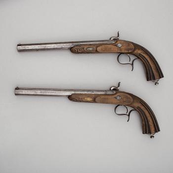 A pair of mid 19th century percussion pistols in a case marked Campagnac a Bordeaux.