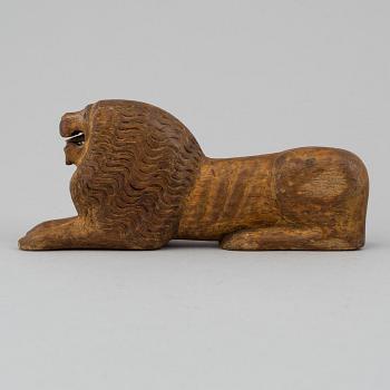 A carved wood sculpture of a lion from the 19th century.