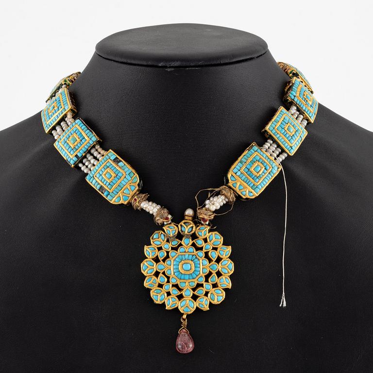 An antique gold and enamel Qajar necklace with pearls set with turquoises and with a garnet drop.