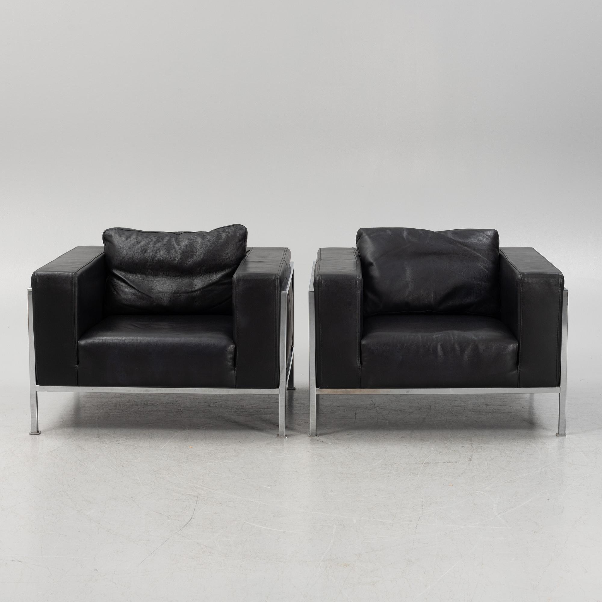 A pair of leather upholstered lounge chairs,