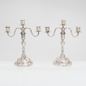 A pair of 18th-century Rococo silver candlesticks from Germany with later candelabra arms. Unindtified maker's mark.