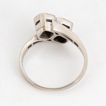 Brilliant-cut diamond crossover ring.