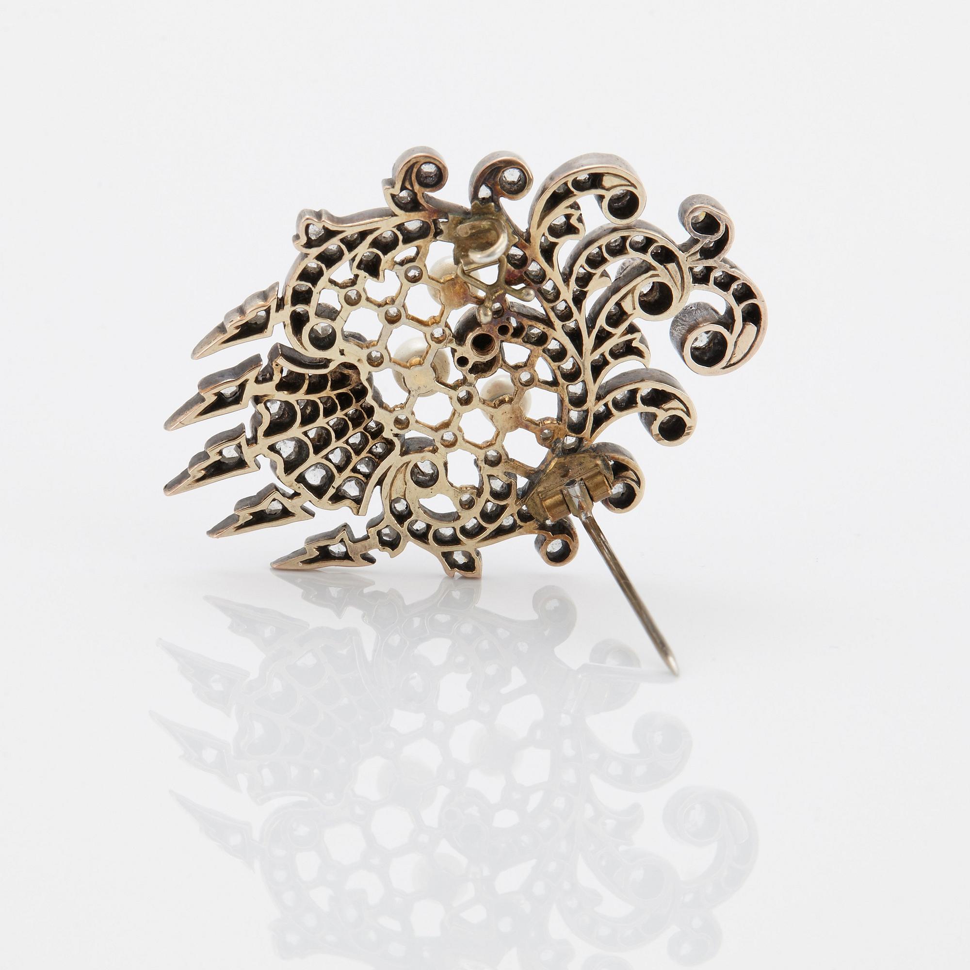 An 18K gold and silver brooch set with old- and rose-cut diamonds.