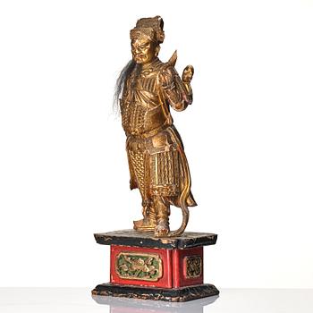 A gilt and lacquered standing figure of a guardsman, Qing dynasty.