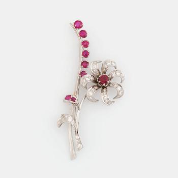 431. A flower brooch in platinum set with faceted rubies and round brilliant- and eight-cut diamonds.