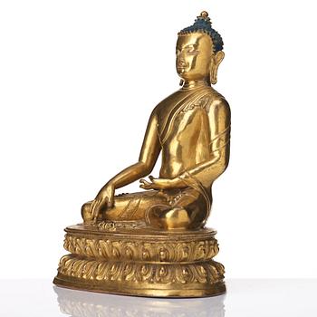 A gilt copper alloy figure of Akhsobya buddha, Tibet, 15th Century.