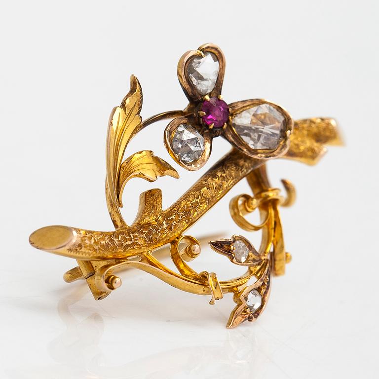 A 14K gold brooch set with rose-cut diamonds and a ruby.