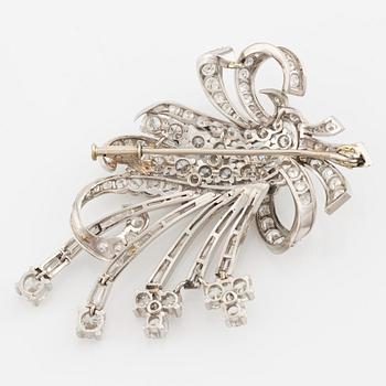 A platinum brooch with round brilliant and baguette-cut diamonds.