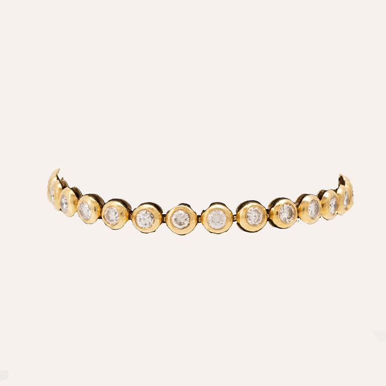 An 18K gold tennis bracelet set with round brilliant cut diamonds.