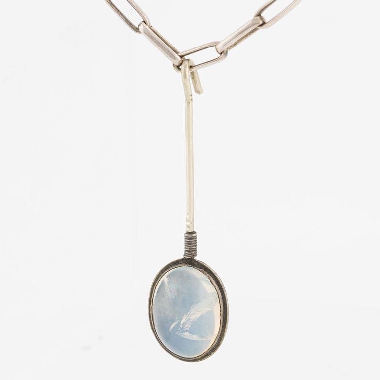 Pendant with silver chain and blue stone, likely moonstone.