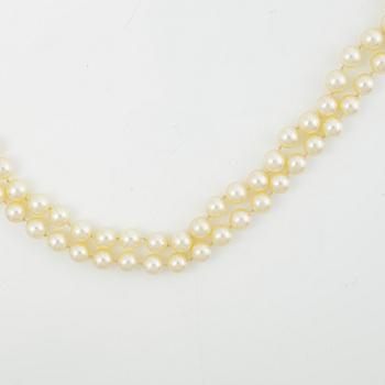 Two necklaces of cultured pearls clasp set with round brilliant-cut diamonds, 18K gold.