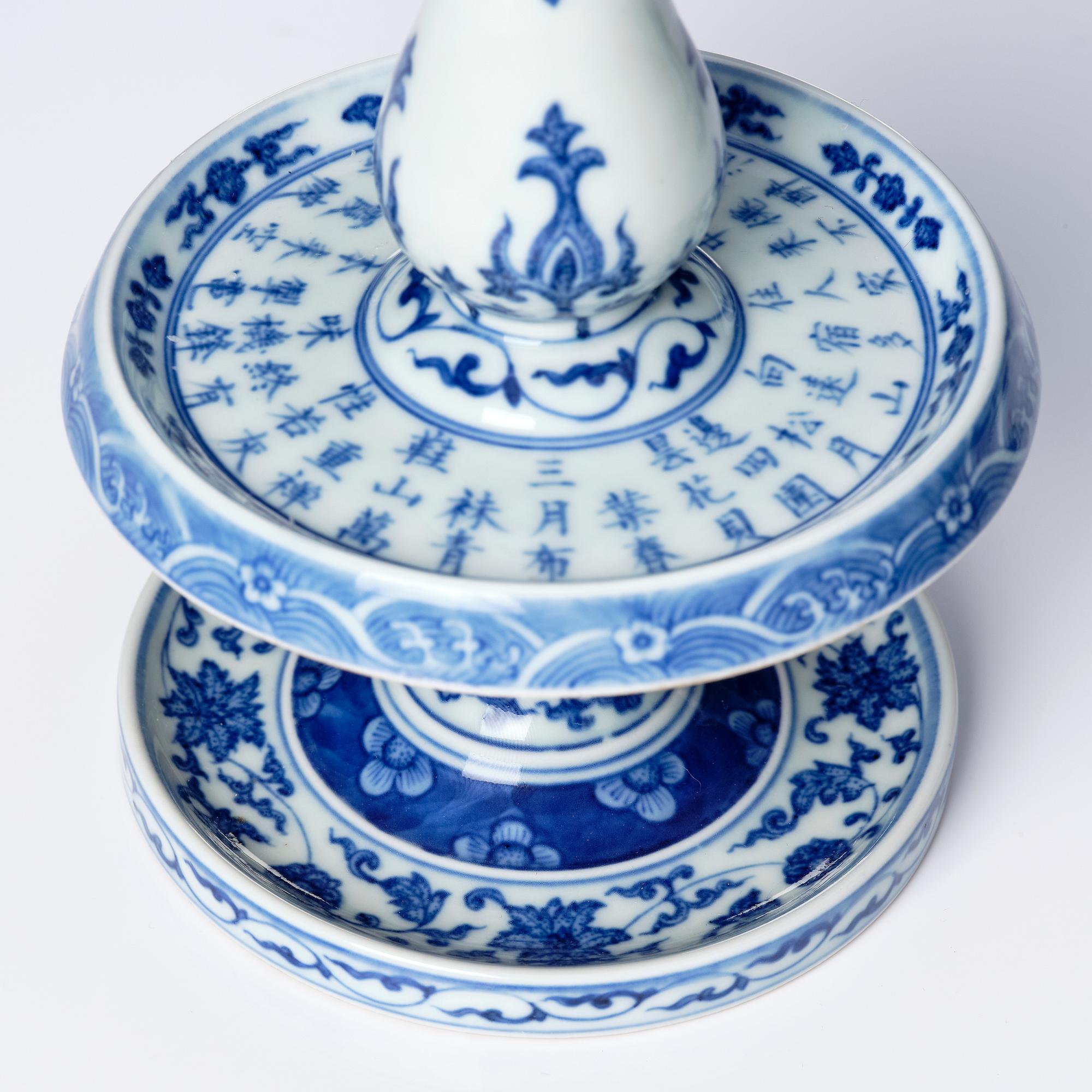 A pair of blue and white pricket candle sticks, with a poem, Qing dynasty with a Qianlong mark and of the period.