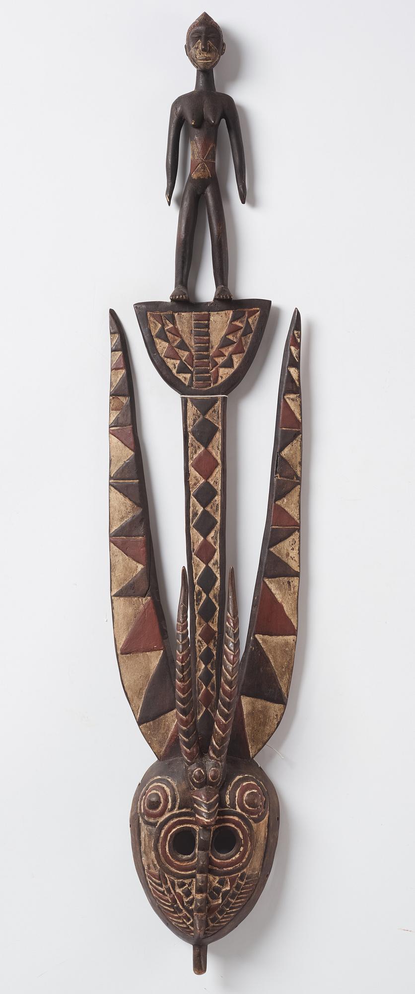 A sculptue and two masks reportedly from The Ivory coast, from the second half of the 20:th century.