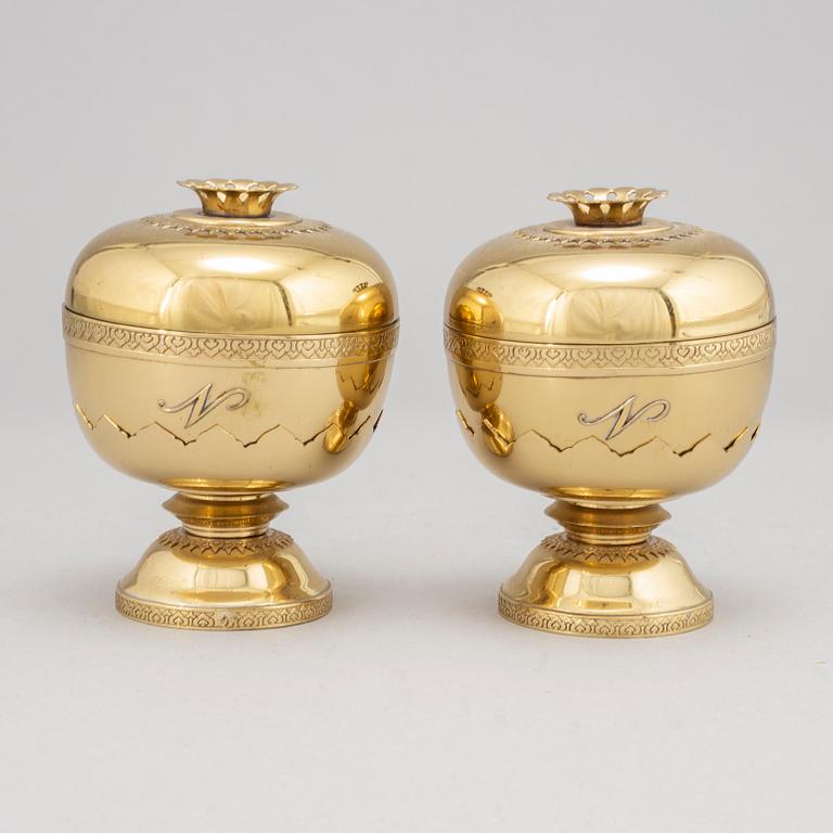 A set of eight polished brass pomme granate shaped jars with covers on stands, Marked Siam, Amfar Co.