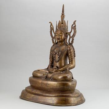 A seated buddha, yellow metal, possibly Nepal, 20th century.