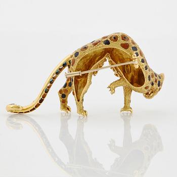 An 18K gold panther brooch set with round brilliant-cut diamonds, sapphires and emeralds.