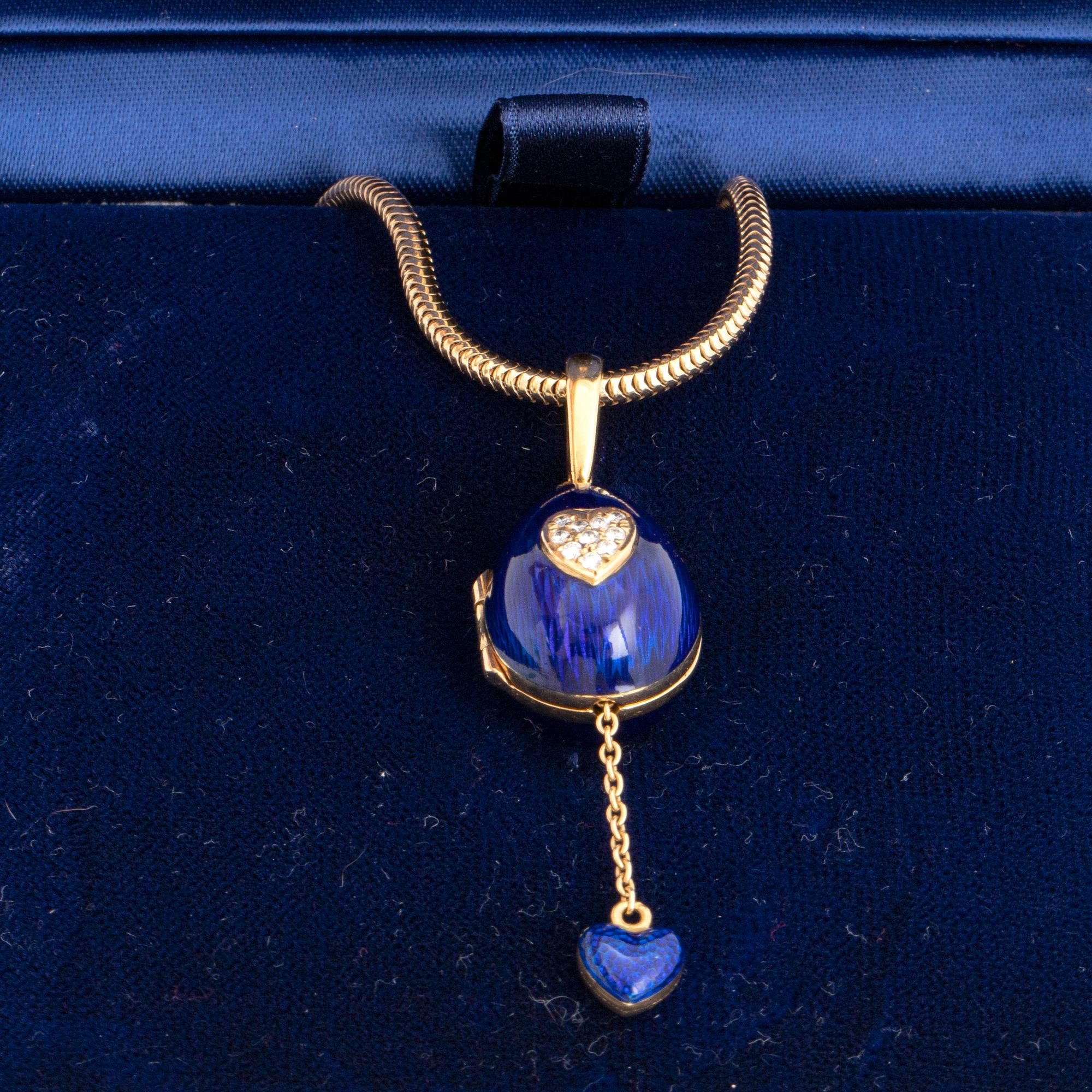 FABERGÉ-ÄGG, 18K guld med blå emalj och runda briljantslipade diamanter, med kedja, med etui.