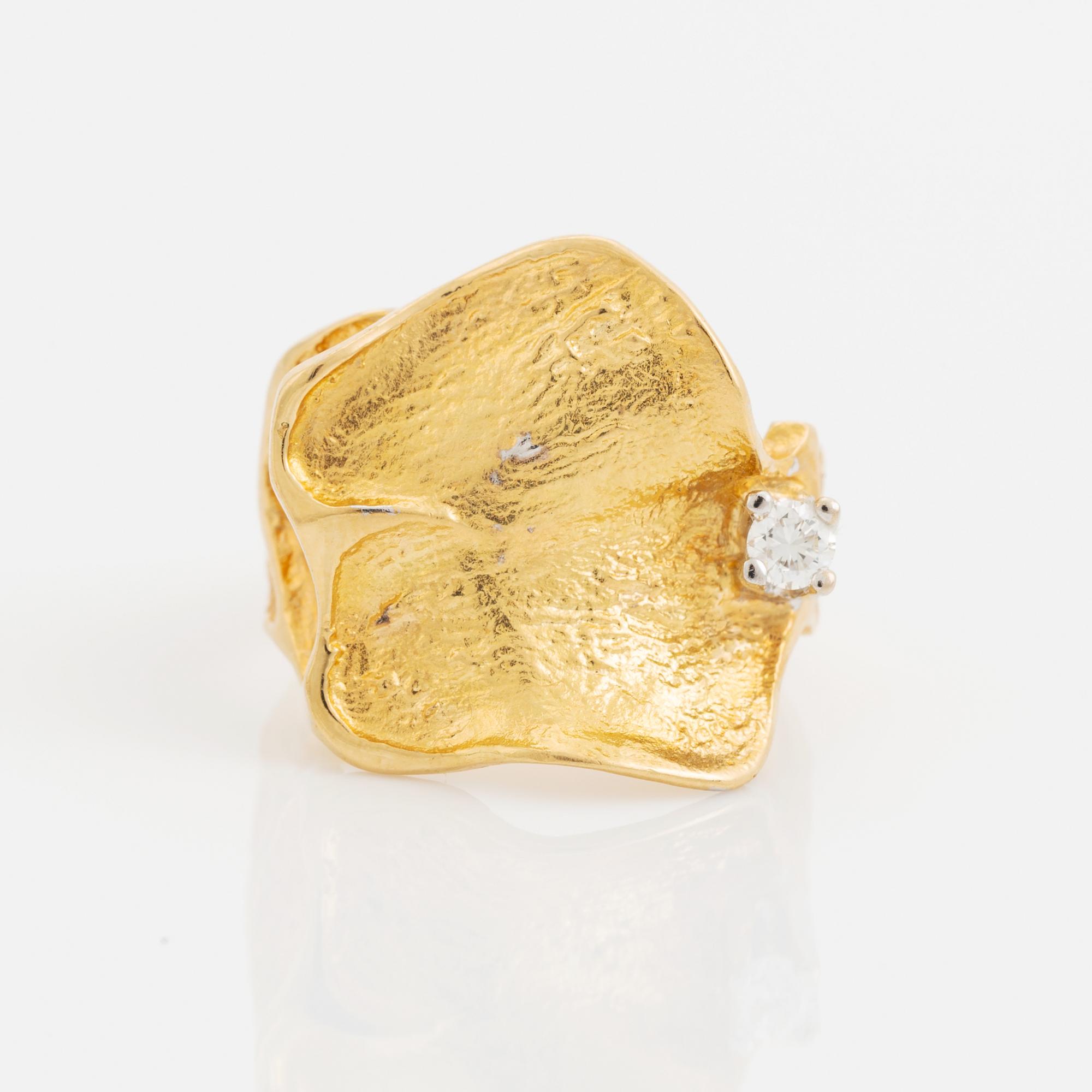 An 18K gold Ole Lynggaard ring set with a round brilliant-cut diamond.
