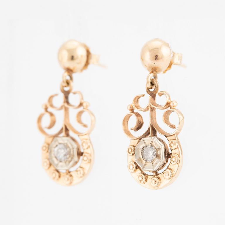 A pair of earrings in 14K gold set with round brilliant-cut diamonds.