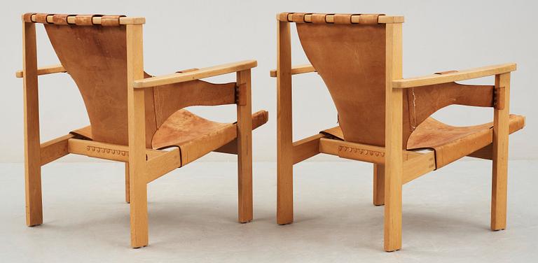 A pair of Carl-Axel Acking oak and beige leather armchairs, 'Trienna', Sweden 1950's-60's.