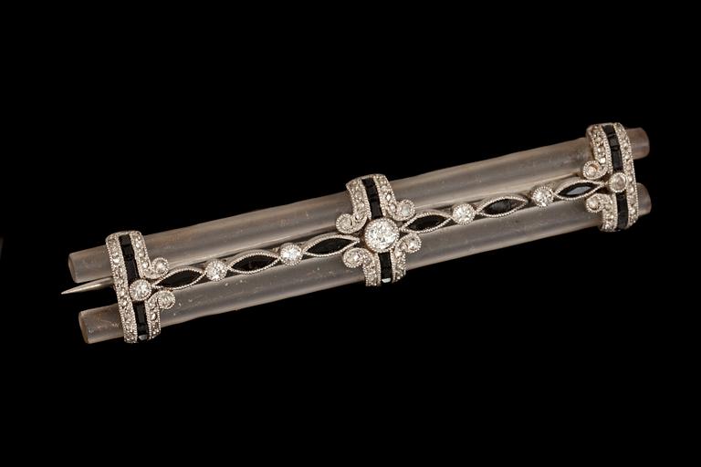 BROSCH, art deco, 1900-talets första hälft. Med små fasettslipade diamanter samt svart sten, på transparent bakelit.