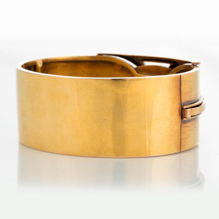 A 14K gold bangle set with a cabochon-cut garnet.