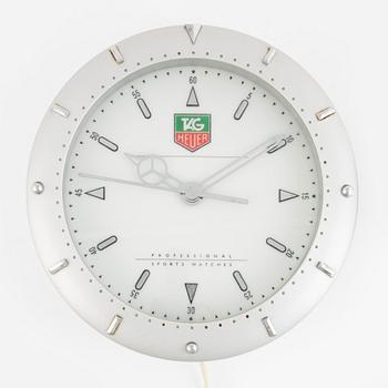 Butik/väggur, märkt "Tag Heuer", ca 35 cm.