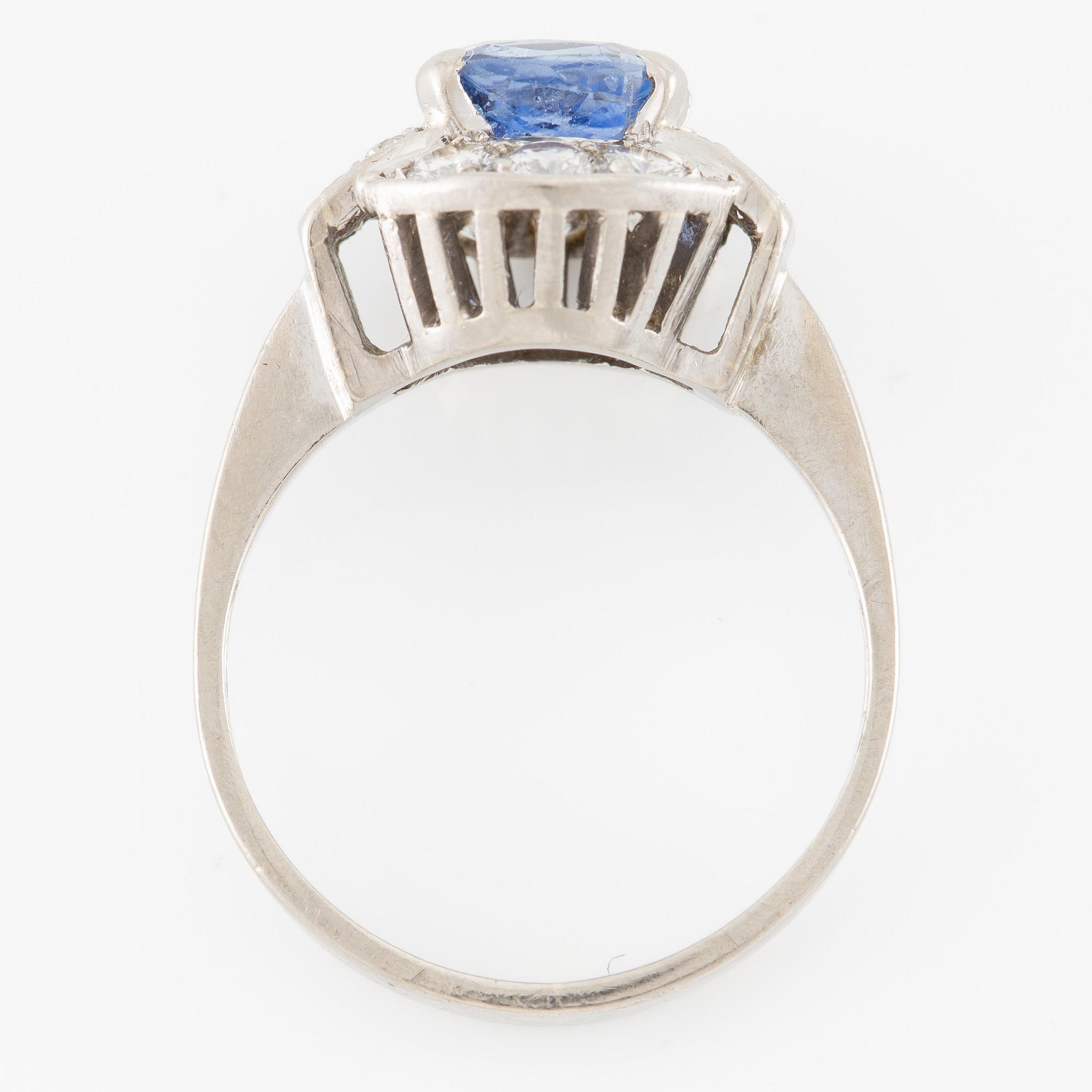 Ring 18K white gold set with a faceted sapphire and round brilliant-cut diamonds.