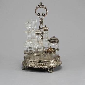 BORDSSURTOUT, 7 delar, vitmetall och glas, omkring år 1900.