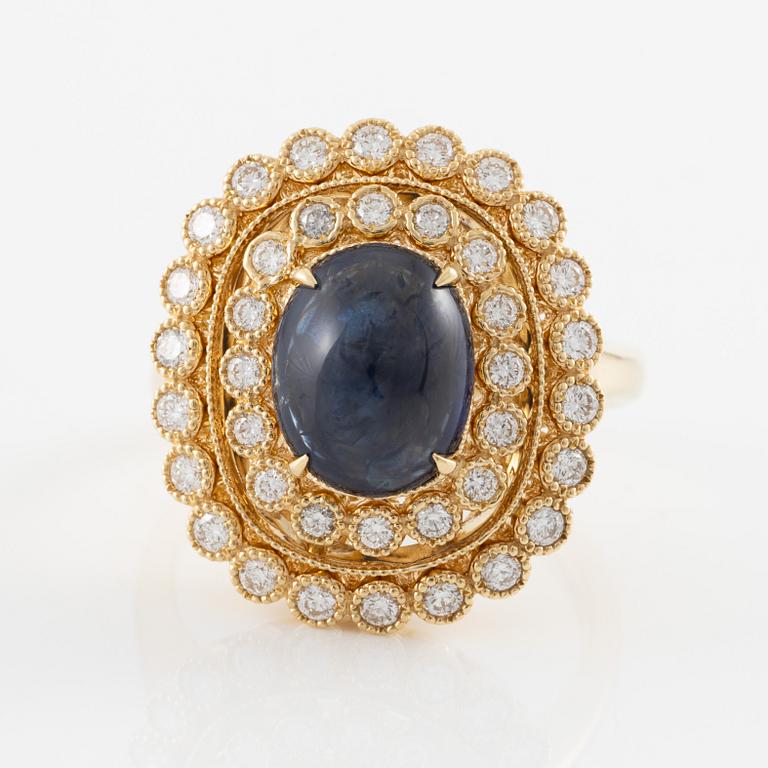 Ring in 18K gold with cabochon-cut sapphire and brilliant-cut diamonds.