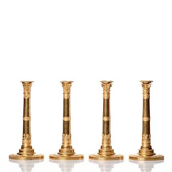 A set of four Empire presumably Russian candlesticks in gilded bronze.