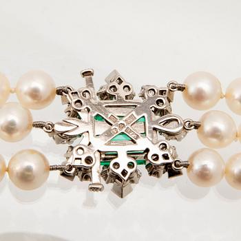 W.A. Bolin, a cultured pearl necklace with an 18K white gold clasp set with an emerald and diamonds, Stockholm 1960.
