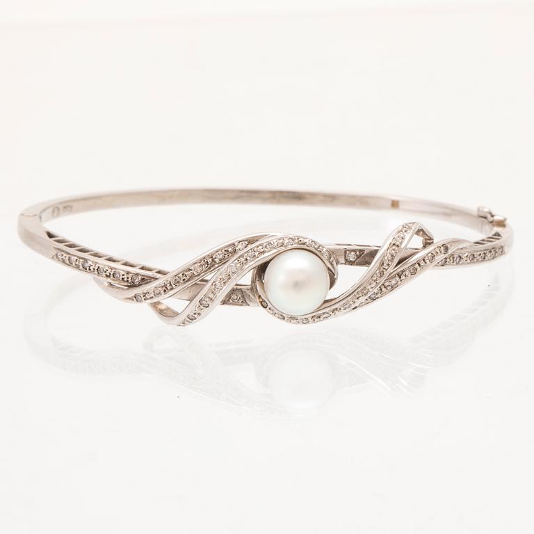 An 18K white gold bracelet with single-cut diamonds and a cultured pearl.